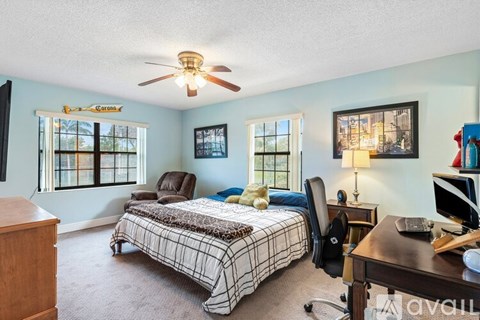 A bedroom with a bed, desk, and chair.