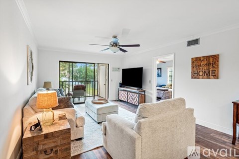 A living room with a couch, chair, and television.
