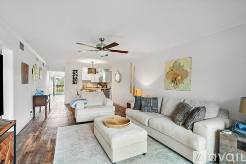 A living room with a white couch and a rug.