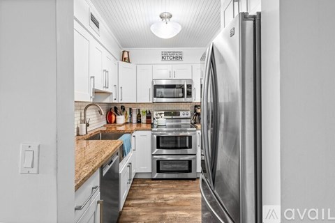 A kitchen with a refrigerator on the right side.