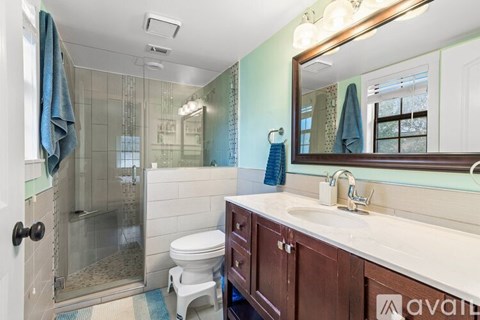 A bathroom with a toilet, sink, and shower.