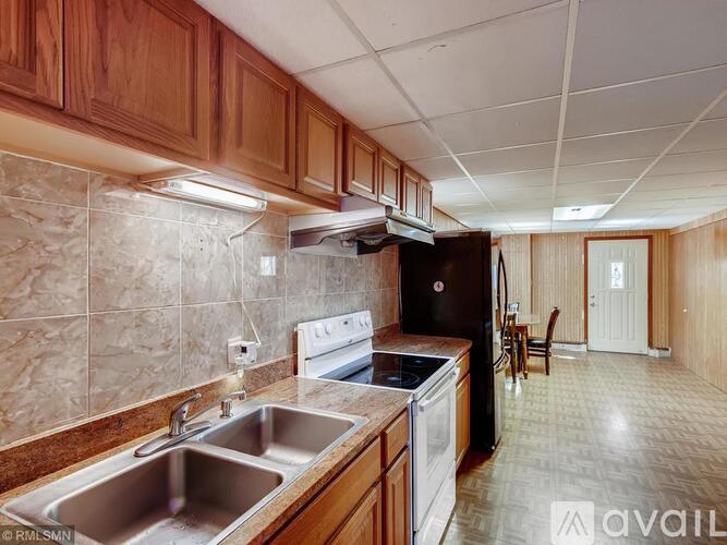 A kitchen with wooden cabinets and a tiled backsplash.