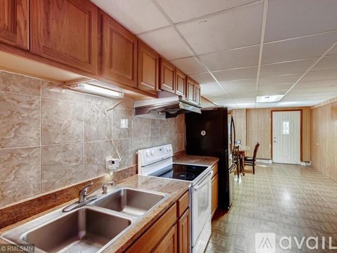 A kitchen with wooden cabinets and a tiled backsplash.