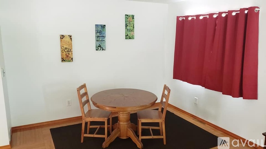 A dining room with a table and chairs.