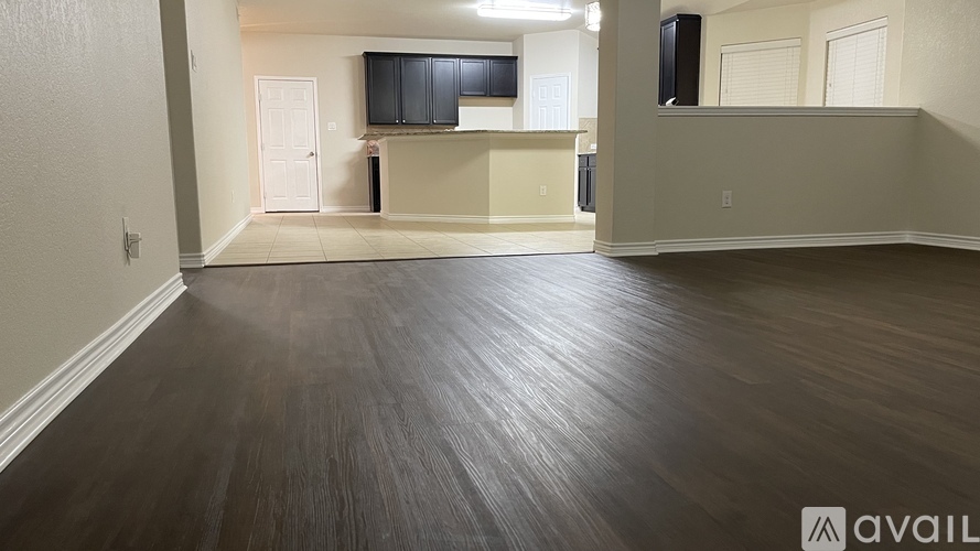 A spacious room with wooden flooring and a television mounted on the wall.