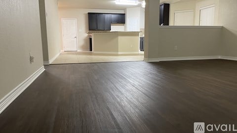 A spacious room with wooden flooring and a television mounted on the wall.