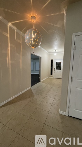 A hallway with a chandelier and a sign that says "available".
