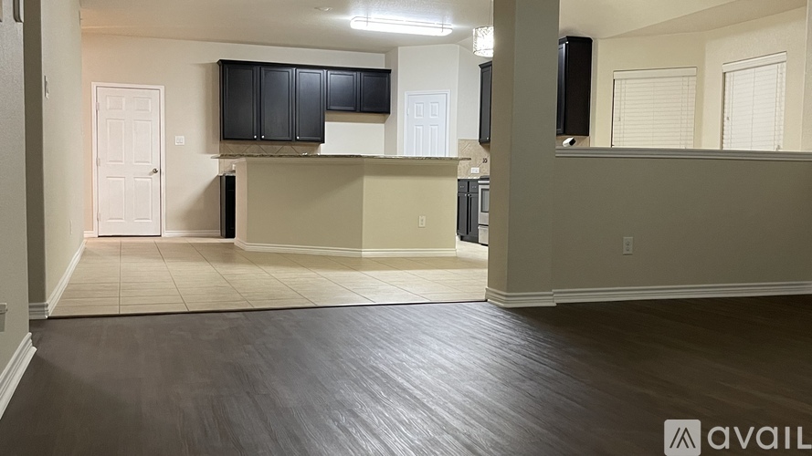 A spacious living room with wood flooring and a television mounted on the wall.