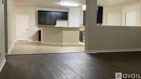 A spacious living room with wood flooring and a television mounted on the wall.