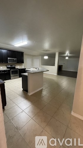 A kitchen with black cabinets and a white island.