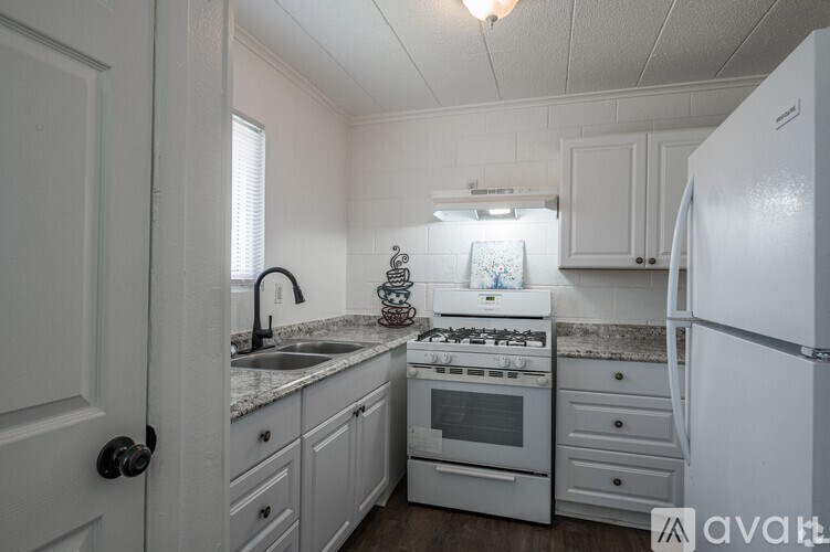 A kitchen with white appliances and cabinets.