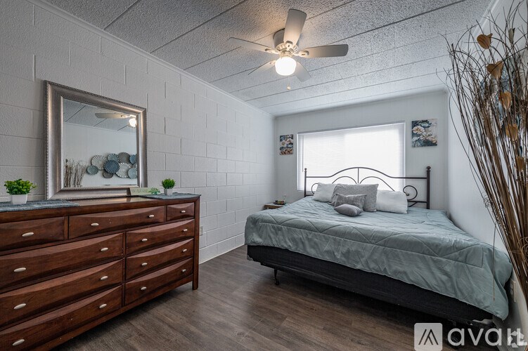 A bedroom with a bed, dresser, and mirror.