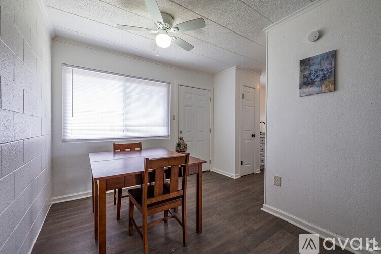 A room with a table and chairs and a ceiling fan.
