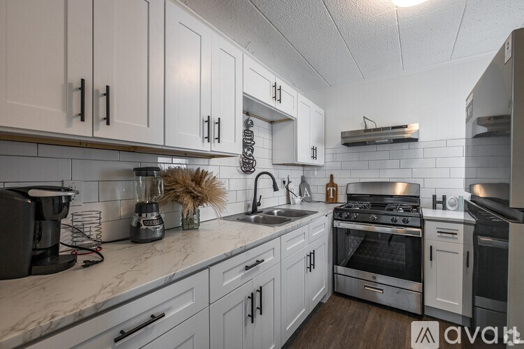 A kitchen with white cabinets and stainless steel appliances.