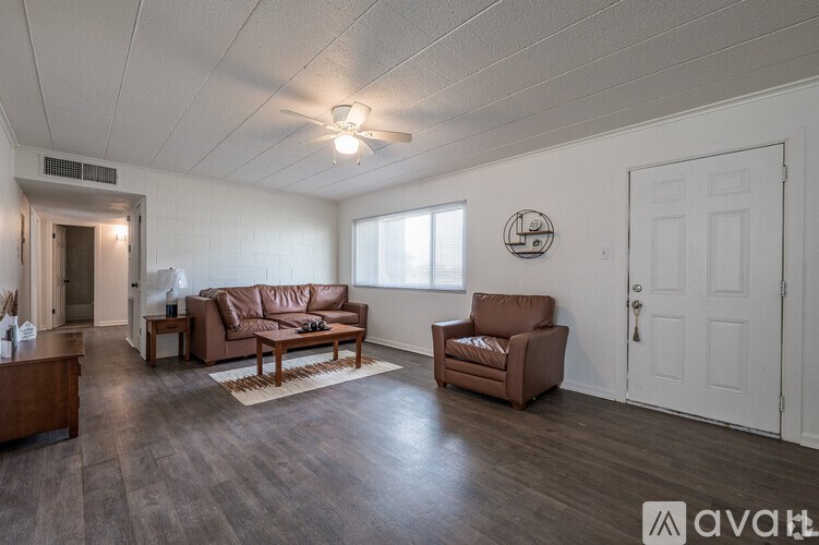 A living room with brown leather furniture and a white door.