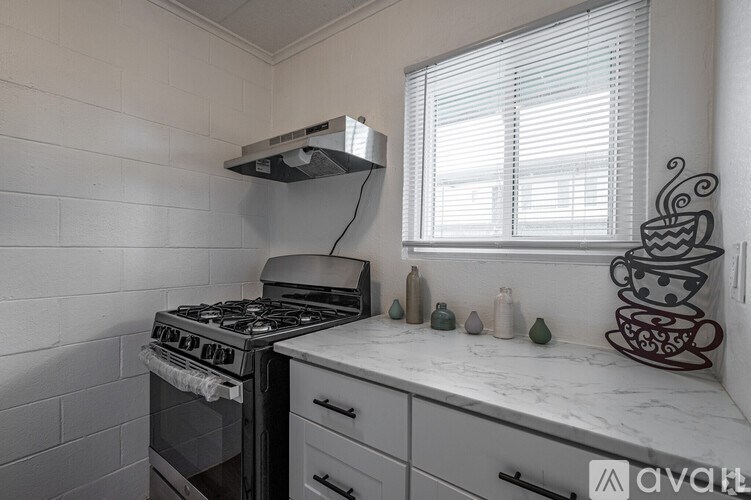 A kitchen with a stove, oven, and a counter with a coffee cup design.