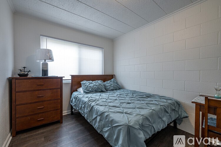 A bedroom with a bed, nightstand, and a dresser.
