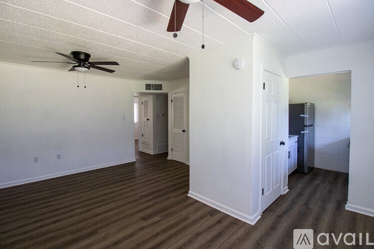 A room with a ceiling fan and wooden flooring.