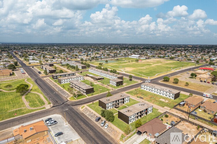 A bird's eye view of a residential area with houses and a football field.