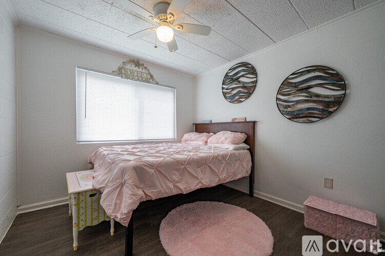 A bedroom with a bed, a window, and two wall art pieces.