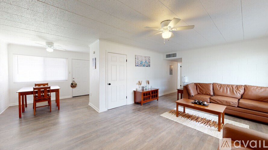 A living room with a brown couch and a wooden table.