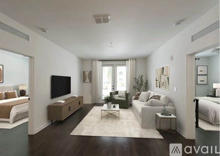 A modern living room with a flat screen TV and a large window with curtains.