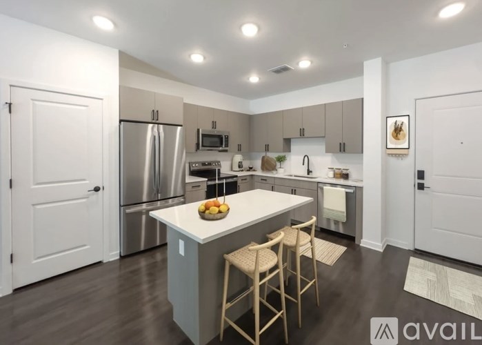 A kitchen with a white island and stainless steel appliances.