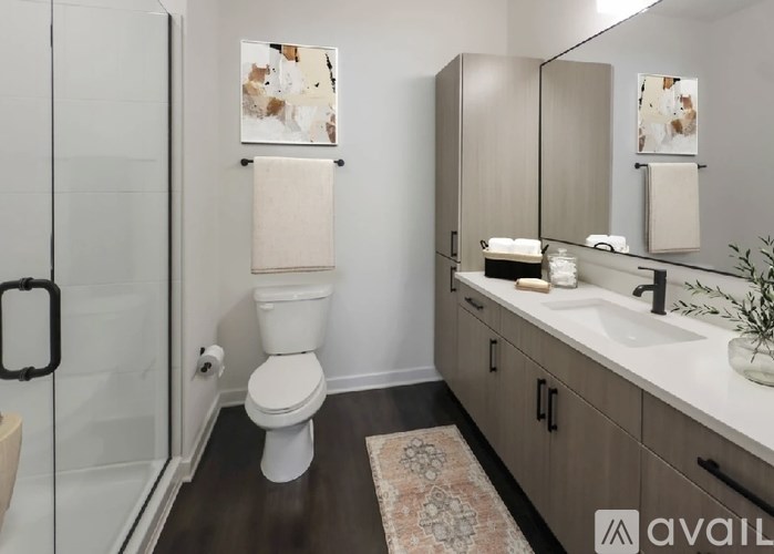 A bathroom with a toilet, sink, and mirror.