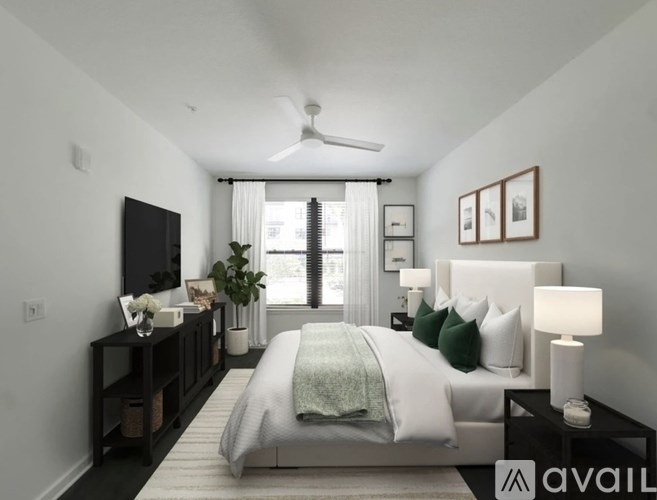 A bedroom with a large bed, a flat-screen TV, and a window with curtains.