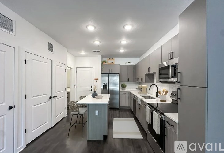 A modern kitchen with stainless steel appliances and white cabinetry.