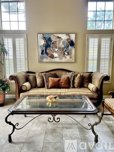 A living room with a couch, coffee table, and chairs.