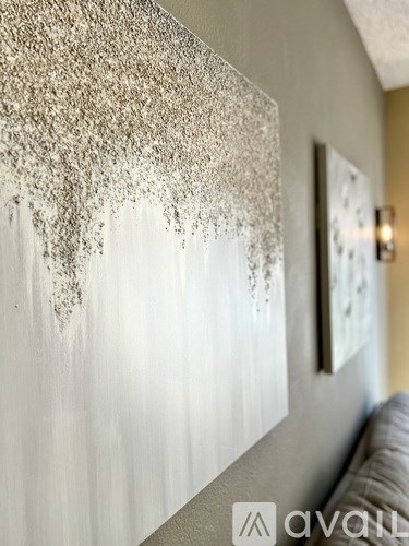 A wall with a painting of a white and grey abstract design.