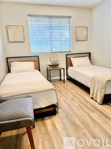 A bathroom with a white toilet, a white sink, and a grey shower curtain.