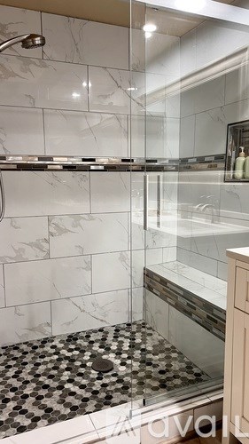 A bathroom with a marble tile floor and a walk-in shower.