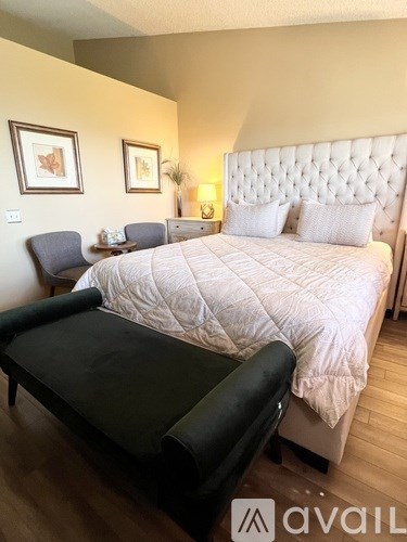 A bedroom with a large bed and a chair.