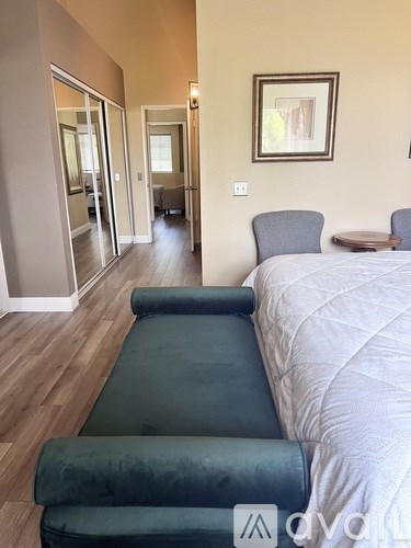 A garden with yellow flowers in the foreground and a fence in the background.