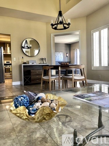 A modern dining room with a glass table and chairs.