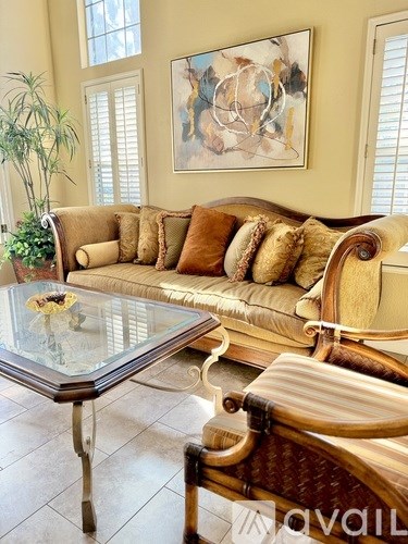 A modern dining room with a glass table and chairs.