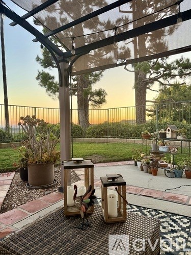 A patio with a lantern and potted plants.