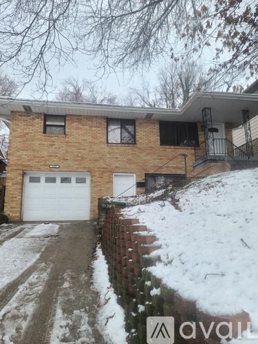 A house with a garage and a driveway covered in snow.