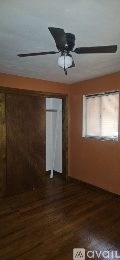 A room with a ceiling fan and a window.