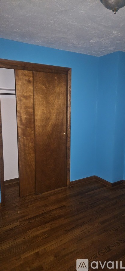 A room with a wooden door and a blue wall.
