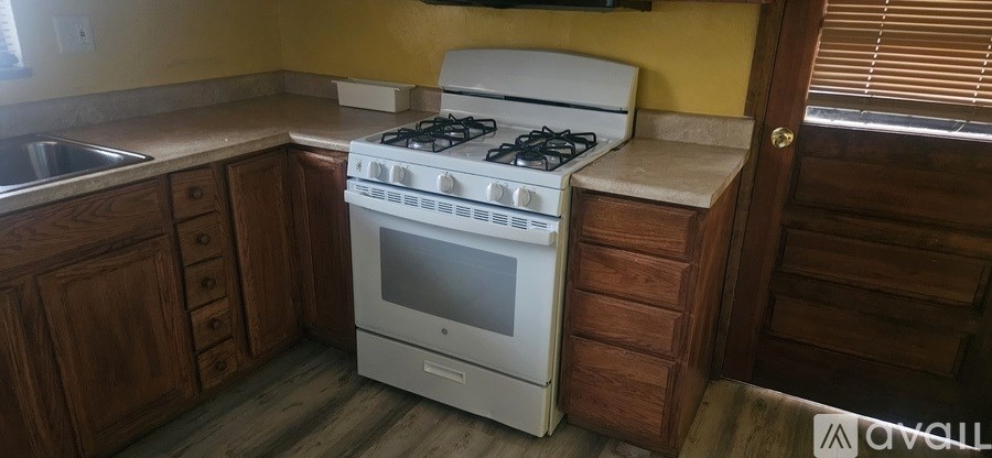 A white gas stove in a kitchen with wooden cabinets.