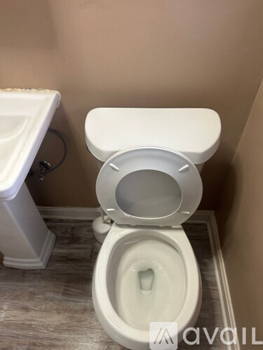 A white toilet with the seat up in a bathroom.