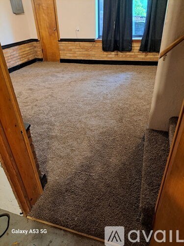 A room with a carpeted floor and a doorway leading to another room.