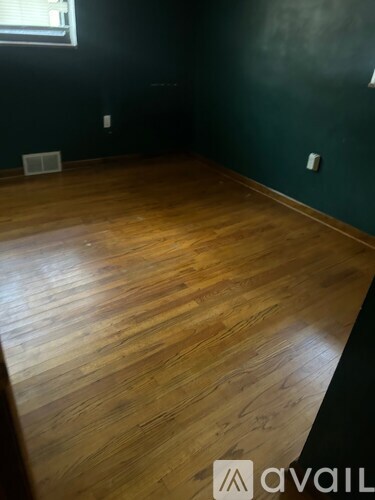 A room with wooden flooring and a window.