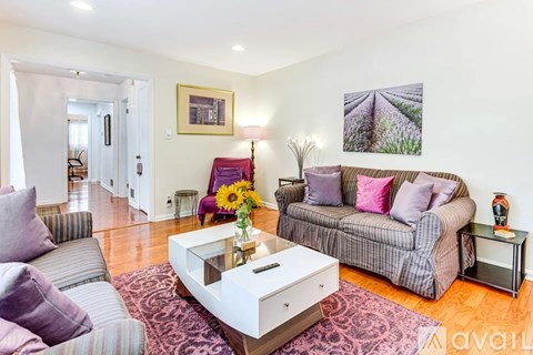 A living room with a grey couch, a coffee table, and a painting on the wall.