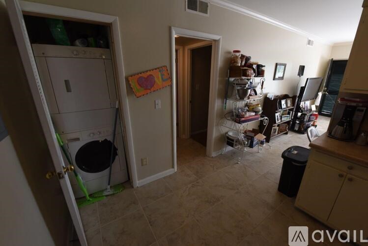 A kitchen with a washing machine in the doorway.