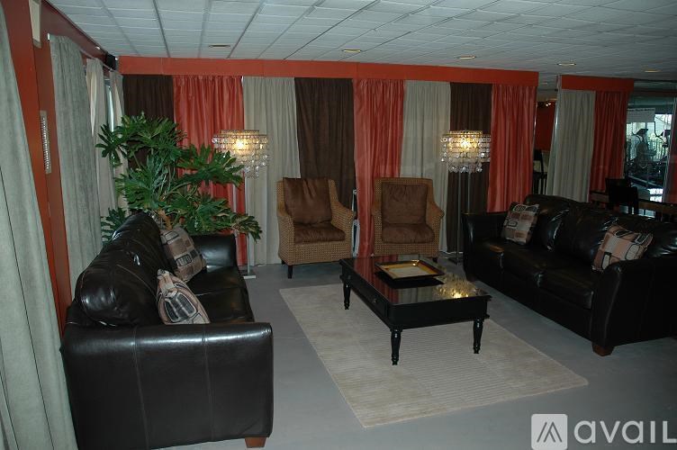 A living room with a black leather couch and a coffee table.