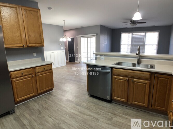 A kitchen with wooden cabinets and a black refrigerator.